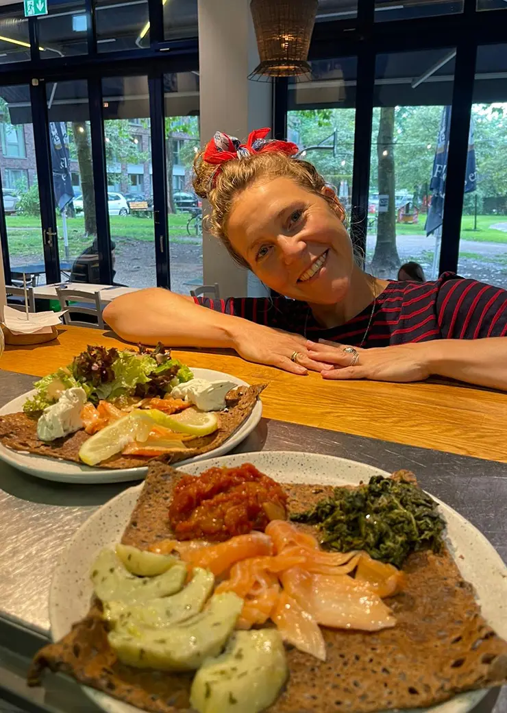 Mitarbeiterin von Ti Breizh, vor ihr stehen zwei Speisen