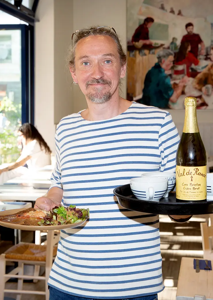 Mitarbeiter von Ti Breizh mit einem Tablett in der Hand