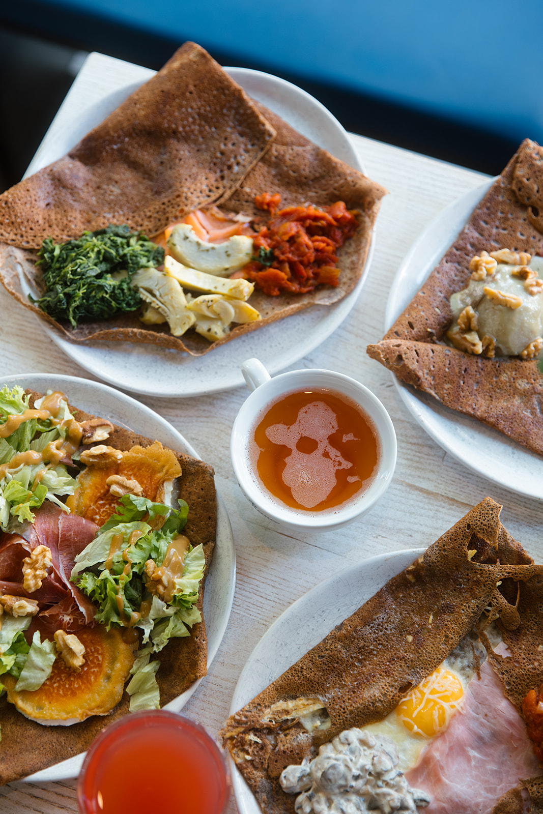 Vier Galettes und Getränke auf einem Tisch