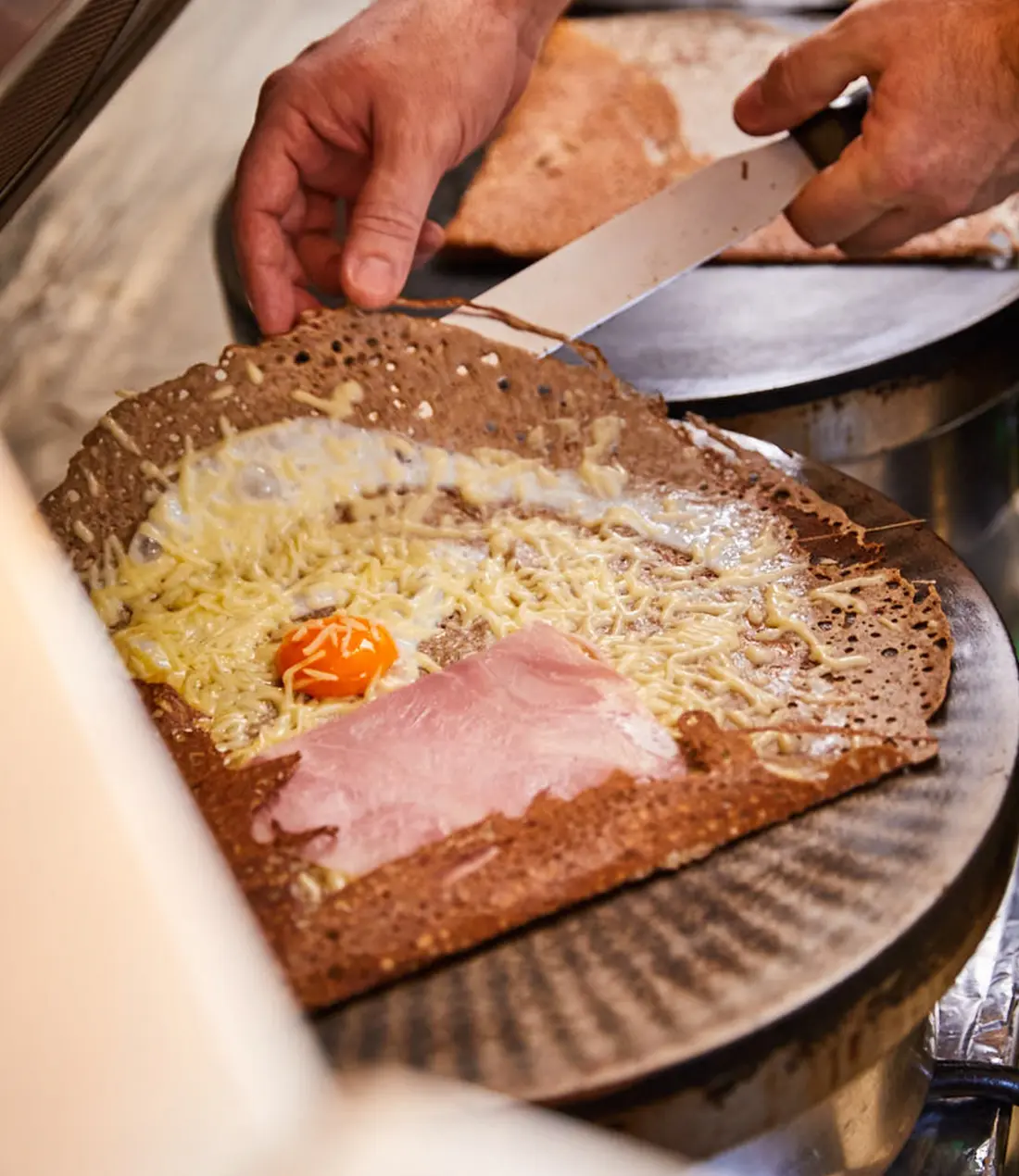 Zubereitung einer Speise mit Käse, Ei und Schinken