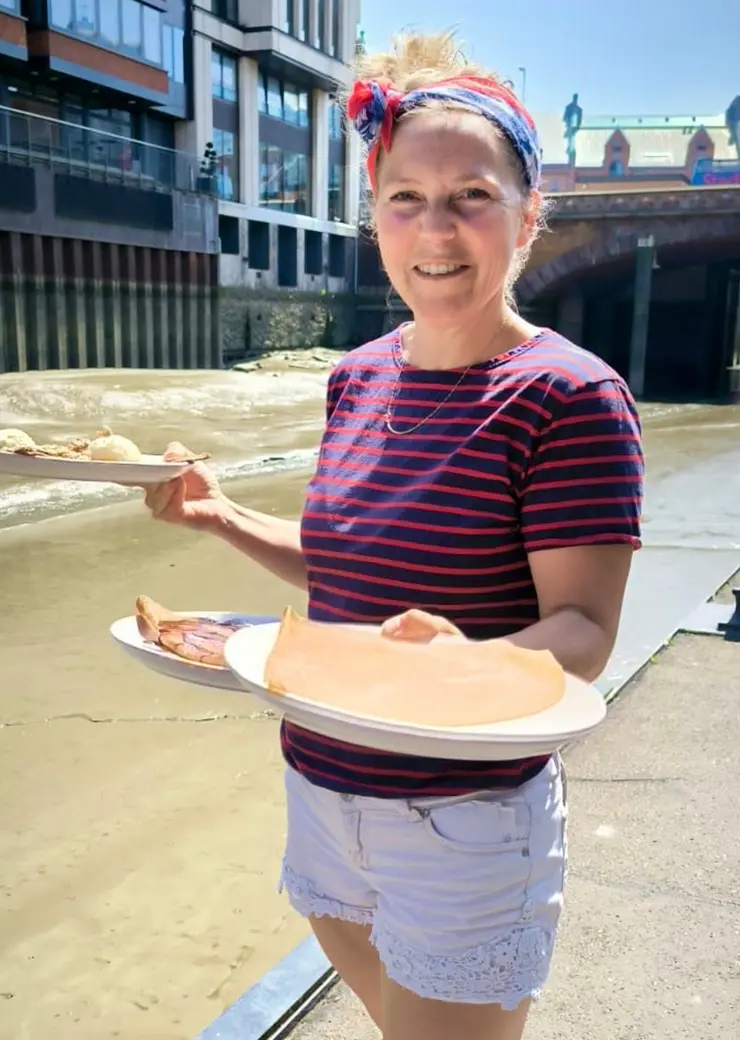 Mitarbeiterin hält 3 Teller mit Speisen auf den Händen